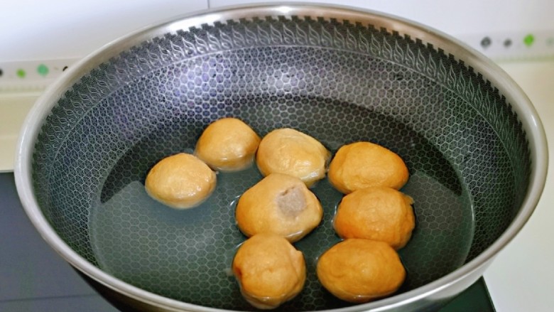 红烧油面筋,首先锅中加入水,再将面筋塞肉下锅。