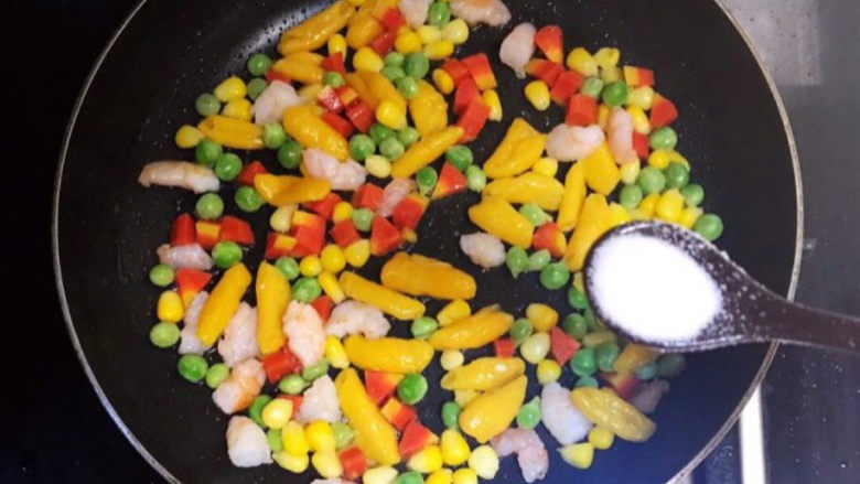 青豆炒虾仁,加入精盐,翻炒均匀