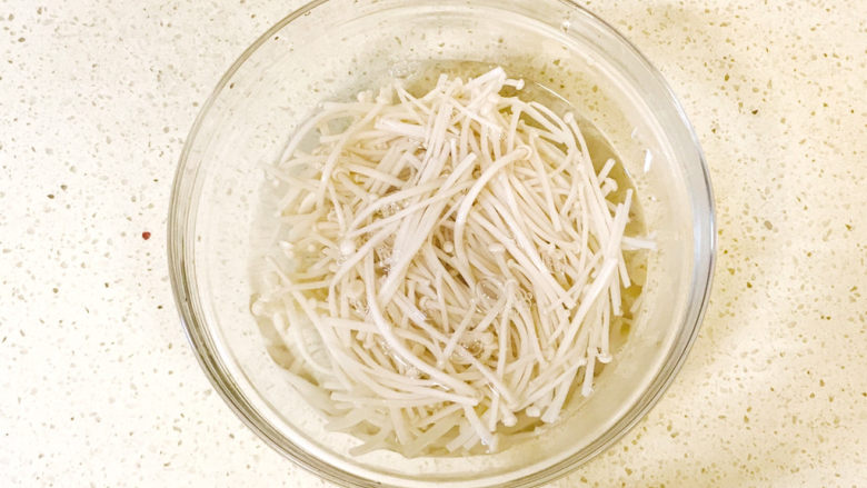 黄瓜凉拌金针菇,装入容器中,加清水过一下水