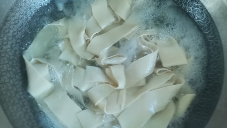 麻辣豆皮,锅里烧开水,下入豆腐皮焯水1分钟,去除豆腥味