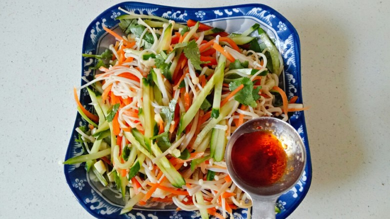 黄瓜凉拌金针菇,根据自己吃辣的程度加入适量<a style='color:red;display:inline-block;' href='/shicai/ 852'>辣椒油</a>,翻拌均匀