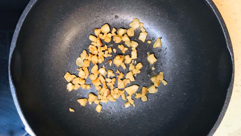萝卜干炒毛豆,投入猪肉渣,翻炒均匀,使猪肉与植物油混合均匀