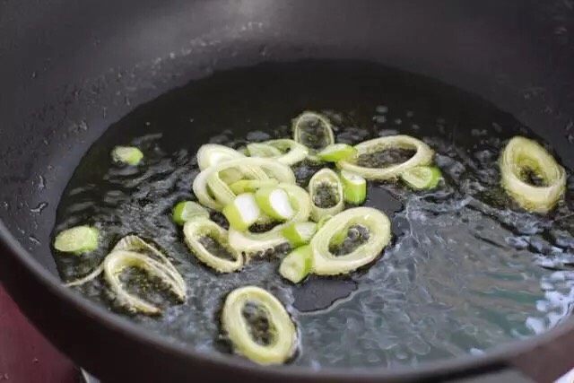 腐竹炒木耳胡萝卜,锅中倒适量食用油烧至五成热,放入葱花小火炒香。