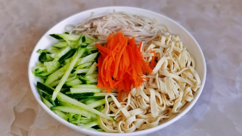 黄瓜凉拌金针菇,金针菇,胡萝卜丝,豆皮条,黄瓜丝装入盘中。