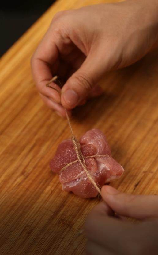 东坡肉,五花肉切成四方小块,在上面系绳绑住
