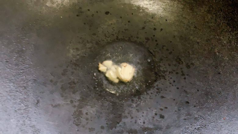 萝卜干炒毛豆,锅烧热油,加入蒜瓣爆炒出香味