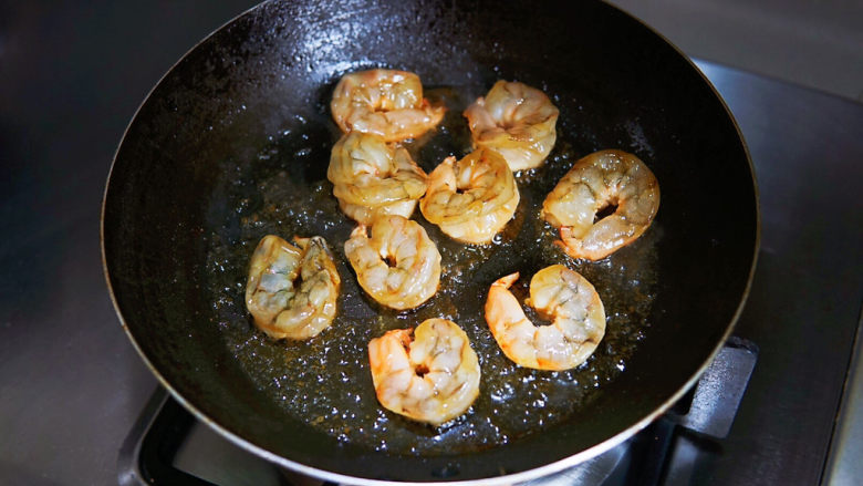 韭菜炒虾米,锅中油热,小火慢慢煎制。