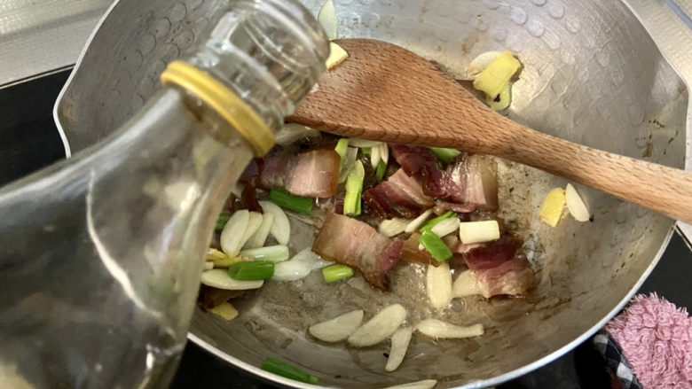 酸豆角炒腊肉,淋一汤匙<a style='color:red;display:inline-block;' href='/shicai/ 718'>料酒</a>,翻炒去腥