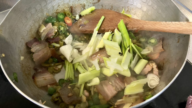 酸豆角炒腊肉,加入蒜白，翻炒断生