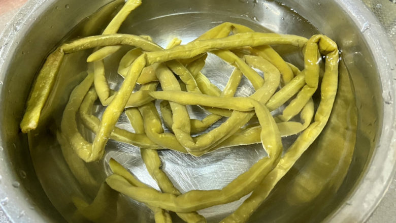 酸豆角炒腊肉,酸豆角取出,清洗,清水浸泡15分钟,以免过咸