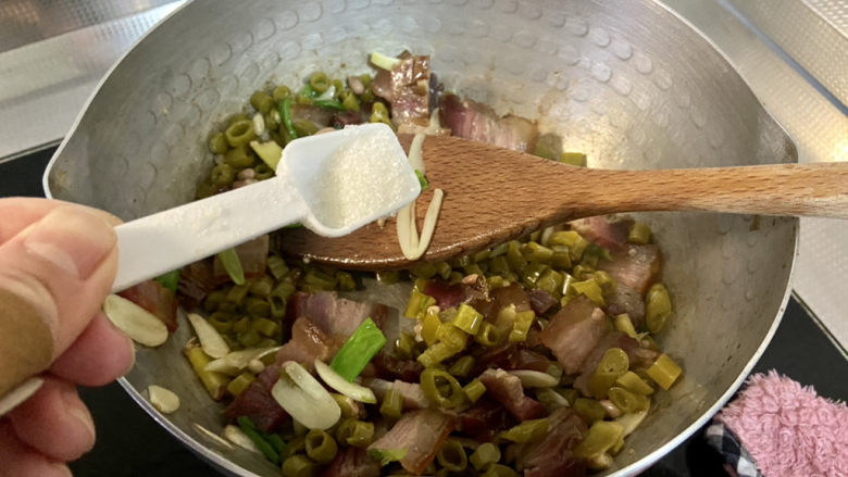 酸豆角炒腊肉,加入半茶匙<a style='color:red;display:inline-block;' href='/shicai/ 3729'>白糖</a>,翻炒一分钟,中和酸豆角的酸味