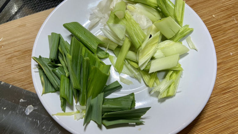 酸豆角炒腊肉,蒜苗择好清洗后,拍一拍,切斜段