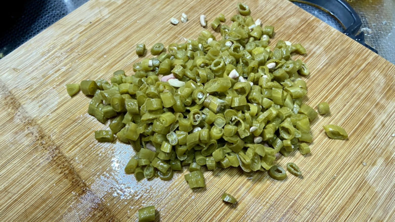 酸豆角炒腊肉,酸豆角挤去水分,切粒