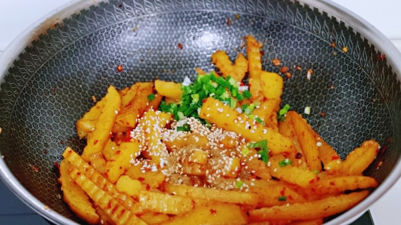 孜然土豆条,最后加入<a style='color:red;display:inline-block;' href='/shicai/ 678'>白芝麻</a>,葱花,翻炒均匀关火。
