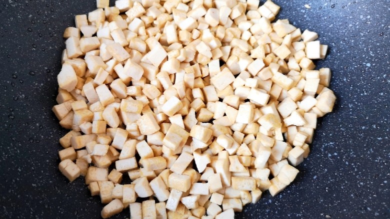 鸡汤米线,炒锅烧热倒入适量的食用油,下入豆腐干小火炒至金黄色。