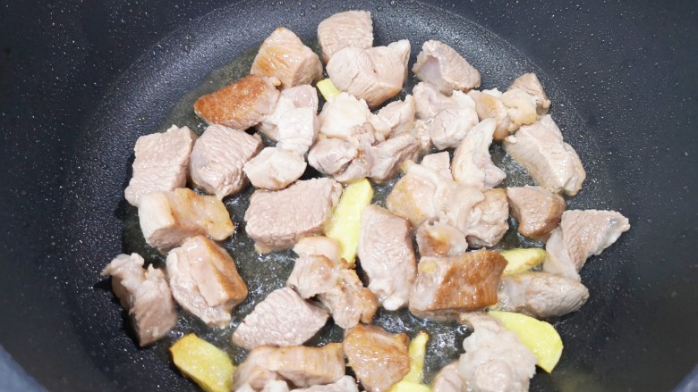 红烧羊肉,炒锅内倒适量的食用油烧热,下入姜片煎出香味,下入羊肉块翻炒至变色。