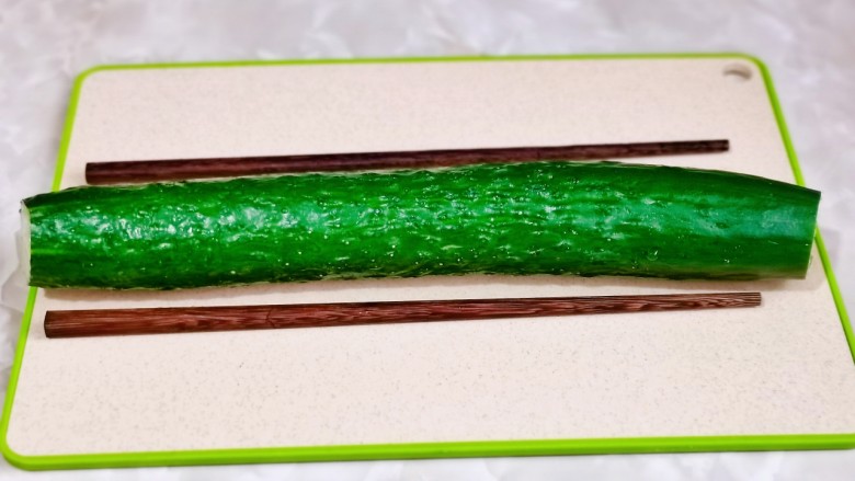 簑衣黄瓜,<a style='color:red;display:inline-block;' href='/shicai/ 54'>黄瓜</a>洗净去跟去尖,放砧板上,两边各垫一根筷子。