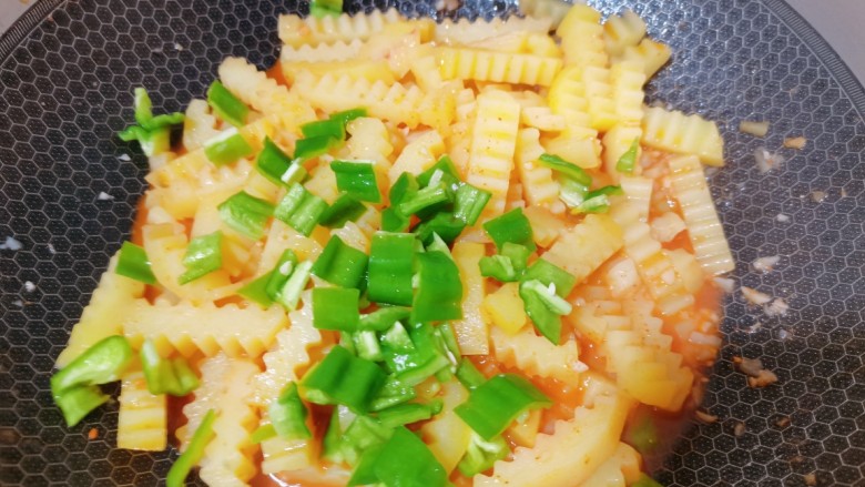 孜然土豆条,最后加入青椒,翻炒均匀