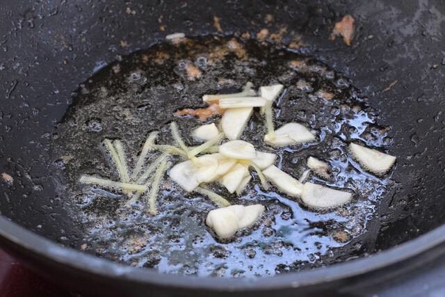芹菜炒虾仁,就锅中底油放入姜丝和蒜片,小火炒出香味。