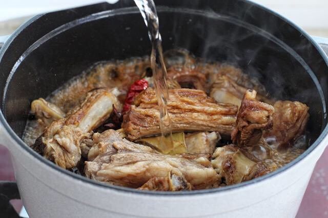 红烧羊肉,倒入热水与羊排持平,盖上锅盖小火炖煮约三十分钟。因为我用的是铸铁锅,密封性能比较好,无需过多的水量也可以在短时间内将羊排炖熟,所以具体水量和时间要根据实际情况来做调整。