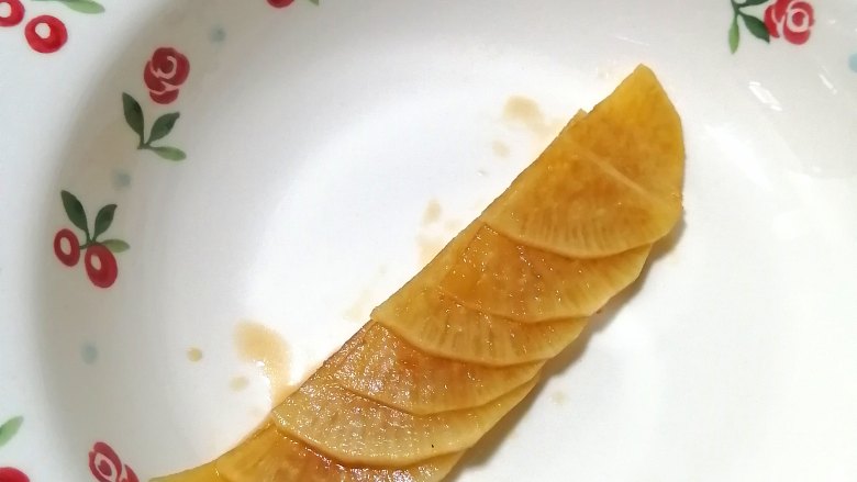 糖醋白萝卜,取切开半片的萝卜片,叠好,然后,由下往上卷起来,卷成一朵花的形状