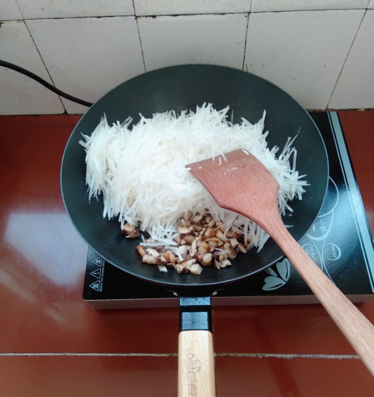 香菇萝卜包,下萝卜丝翻炒均匀,盖上盖子煮几分钟