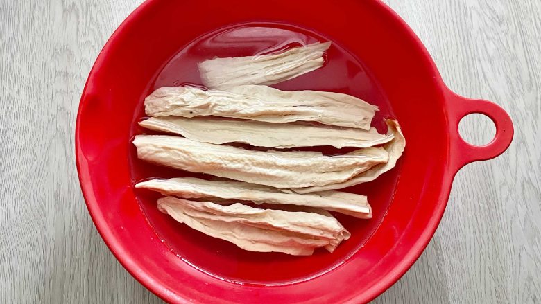 节后清清肠胃,芹菜炒腐竹安排上!,把干腐竹放入凉水里,浸泡一夜,把腐竹泡发。