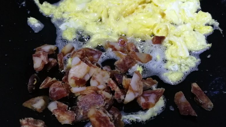 腊肠炒饭,鸡蛋推到一边,放入干肠。