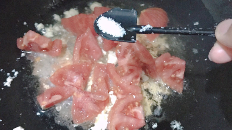 西红柿炒豆腐,倒入西红柿,加入一勺盐翻炒出汁