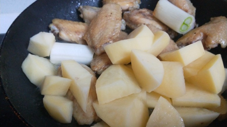 土豆炖鸡翅,鸡翅煎制金黄放姜片葱段,土豆。