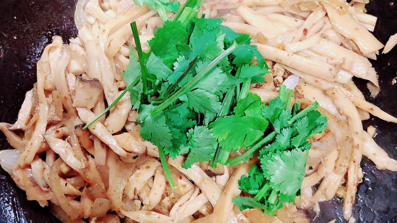 孜然杏鲍菇,撒上香草段,翻炒均匀。