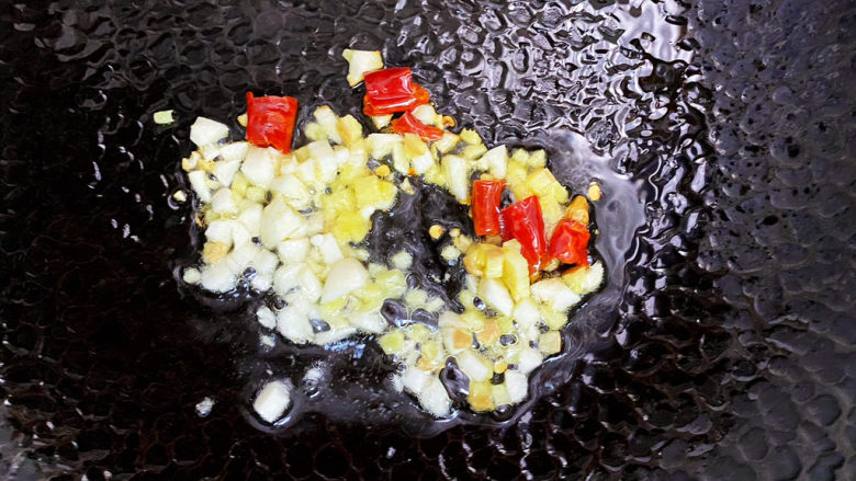 雪菜豆腐,锅里热油,放入蒜、姜、干辣椒炒香。