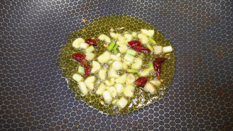 西红柿炒豆腐,炒锅内倒适量的食用油烧热,下入葱、蒜和干红辣椒炒香。