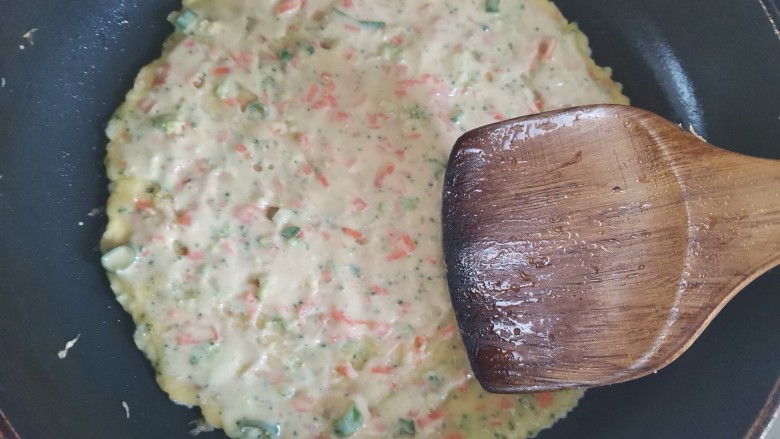 胡萝卜鸡蛋饼,用铲子把面糊摊均匀摊成饼状