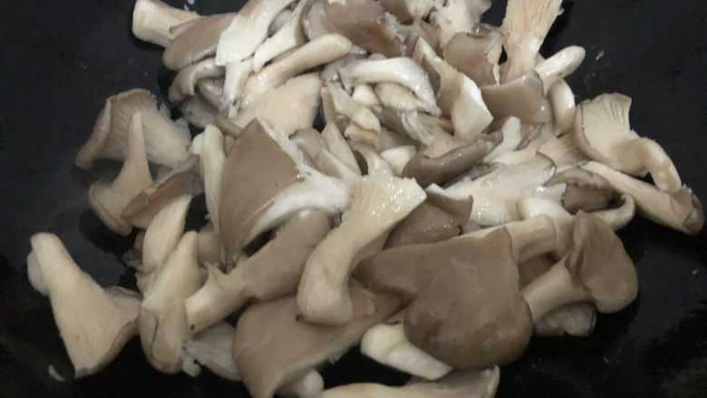 青椒炒平菇,翻炒一下转中小火盖上盖煮三分钟左右(不用加水,会自己出水)