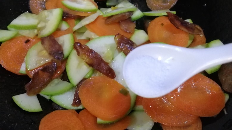 胡萝卜炒腊肉,加半小勺盐,炒匀入味。