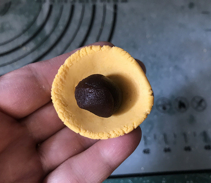 南瓜汤圆,取一个小剂子按成小窝状,放上豆沙球