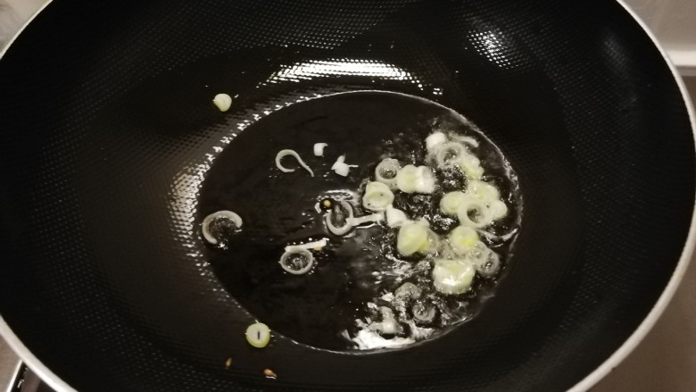 西红柿炒土豆片,起油锅放入食用油,油热后放入葱片炒出香味。