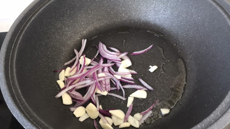 青椒炒平菇,放入洋葱和蒜炒香;