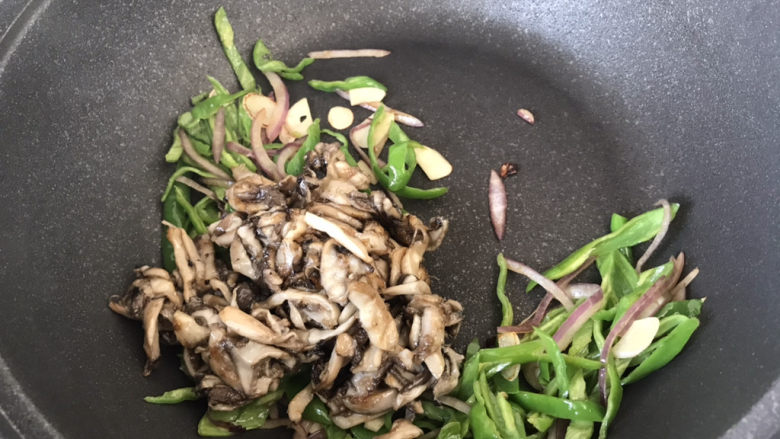 青椒炒平菇,把刚才煎好的平菇倒入锅中;