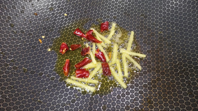 胡萝卜炒腊肉,锅里继续倒油烧热,下入姜丝和干红辣椒炒香。