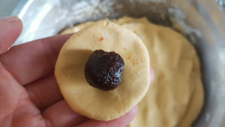 南瓜汤圆,揪一块面团压成饼状,包入豆沙馅