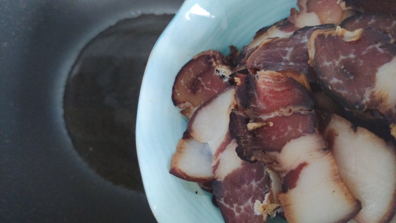 胡萝卜炒腊肉,待锅内油热,下腊肉