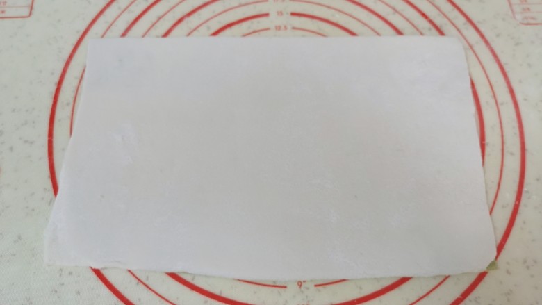 水果汤圆,将两种糯米面团分别擀成长方形,重叠在一起,用塑料刮刀切去边缘部分,切下来的面团继续揉成团。