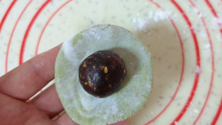 水果汤圆,将一个小糯米面团用手压扁,放上枣泥果仁馅。