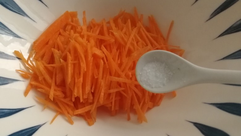 胡萝卜鸡蛋饼,胡萝卜丝放入大碗里,加一点点盐。