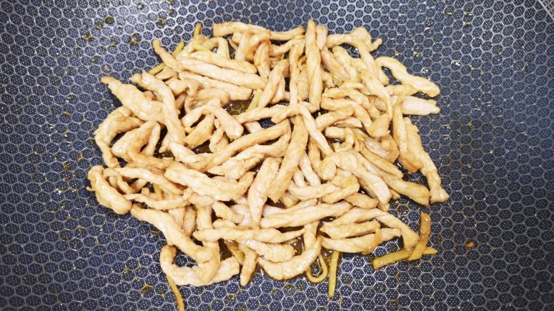 青椒炒平菇,炒锅内倒适量的食用油烧热,下入腌好的肉丝大火翻炒至变色,盛出备用。