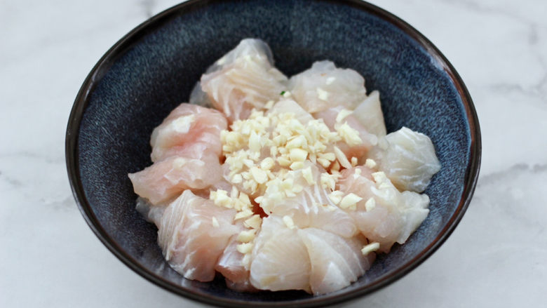 蒜香麻辣龙利鱼,鱼块放入盆中,加入切碎的<a style='color:red;display:inline-block;' href='/shicai/ 2794'>大蒜</a>末。