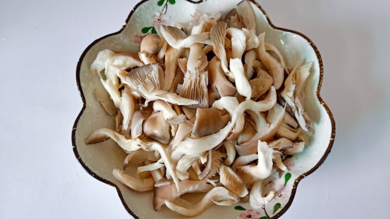 青椒炒平菇,洗好的平菇撕成小块,挤干水分。