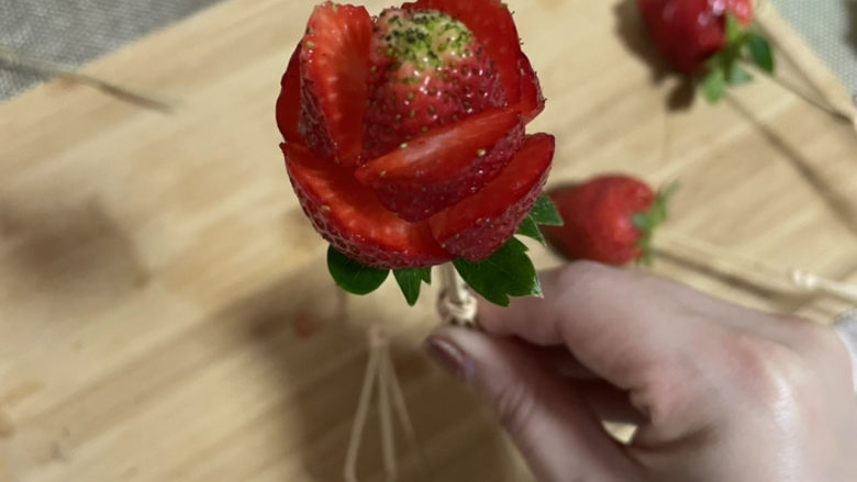 拨丝冰糖草莓,用小刀轻轻切成玫瑰花形,插上竹签